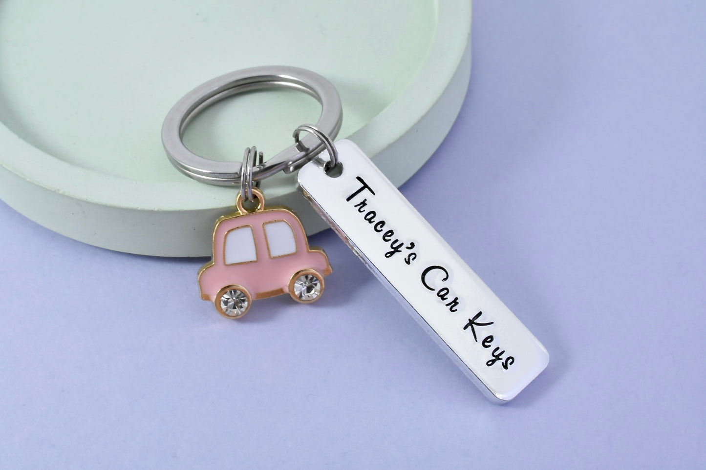 A personalised aluminium car keyring with a pink car charm and a custom name imprint. The keyring is rectangular with a split ring on one side. For newly passed driver