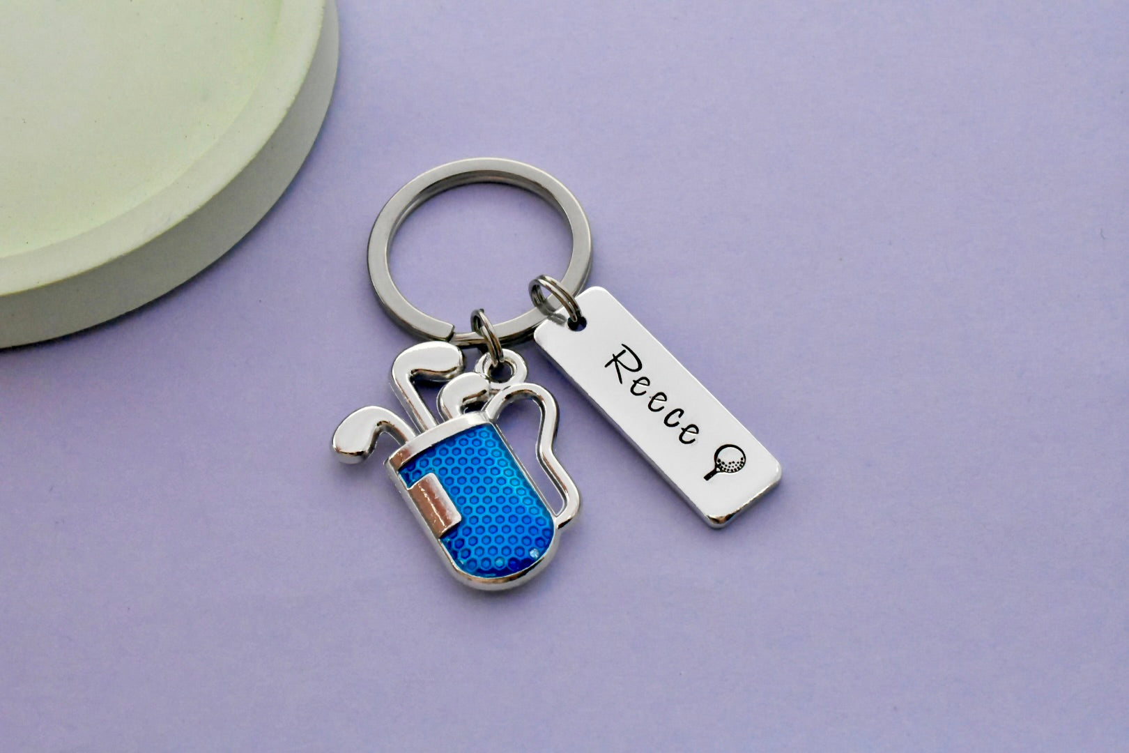 Personalised golf keyring with engraved name, golf ball on tee design and blue golf charm, handmade in the UK