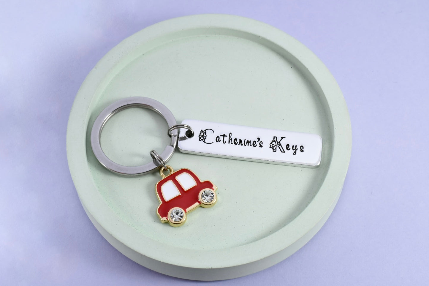 A personalised aluminum keyring with a car charm, engraved with a name and 'Car keys' with red car charm
