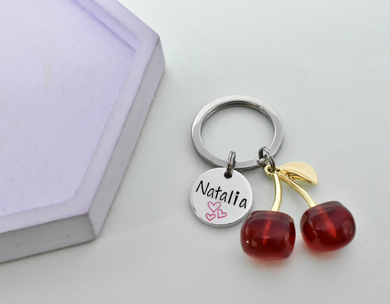 Keychain with cherry charms and a name tag on a light background