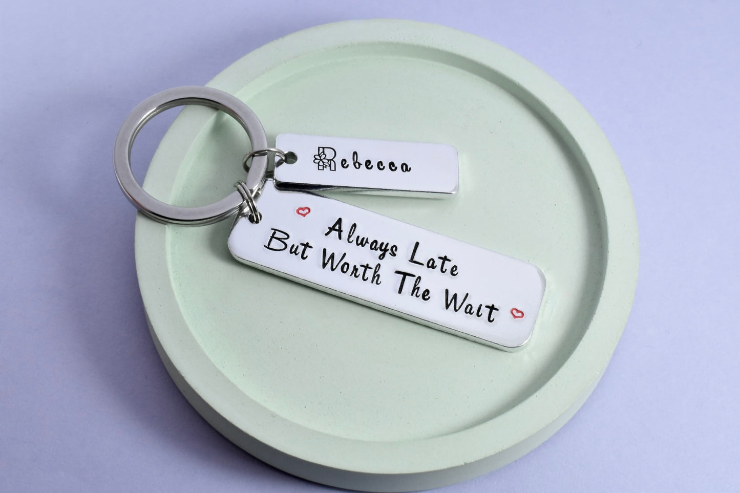 Silver aluminium keyring, larger rectangle says "Always Late But Worth The Wait" with small red heart designs. Smaller silver tag is personalised with a name.