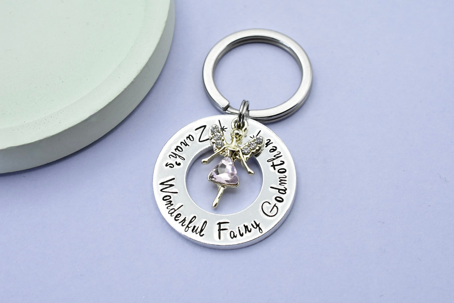 A personalised aluminum keyring with a fairy charm, persoanlsied with the text 'Zarah's Wonderful Fairy Godmother' 
