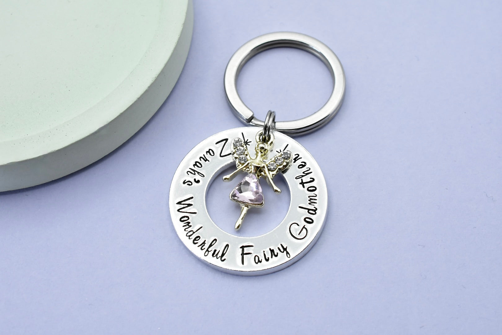 A personalised aluminum keyring with a fairy charm, persoanlsied with the text 'Zarah's Wonderful Fairy Godmother' 