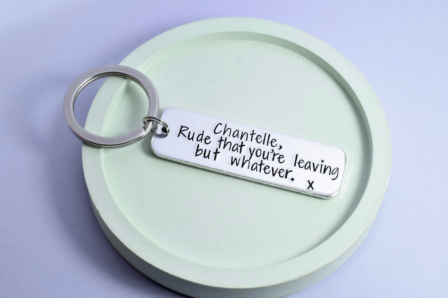 Personalised silver rectangle keyring, for someone that is leaving you. Reads "rude that you're leaving but whatever."