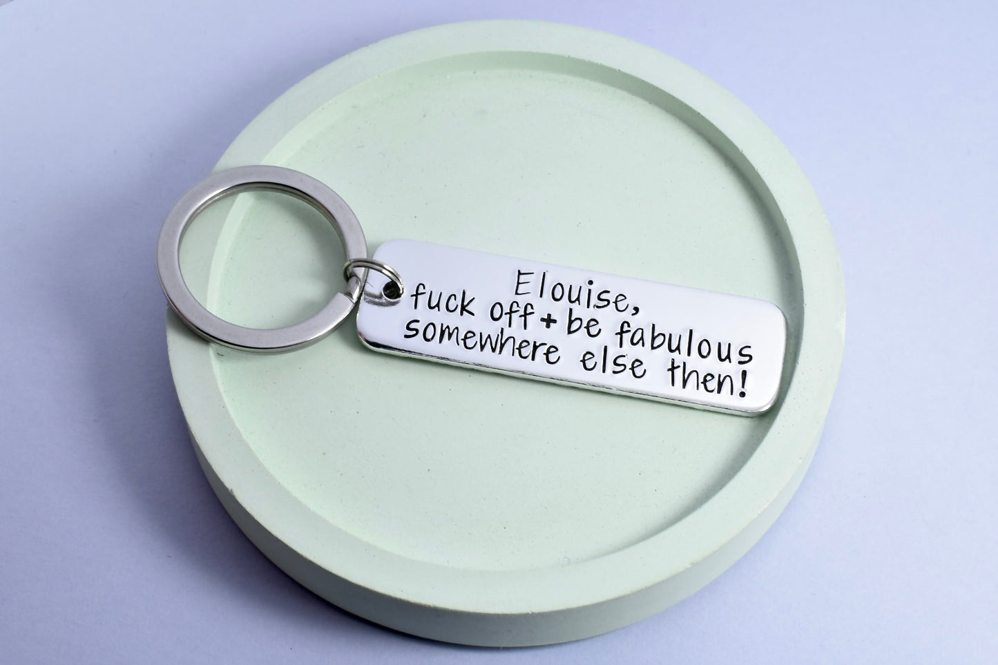 Personalised, aluminium rectangle keyring for someone leaving you. Text says "fuck off and be fabulous somewhere else then!"