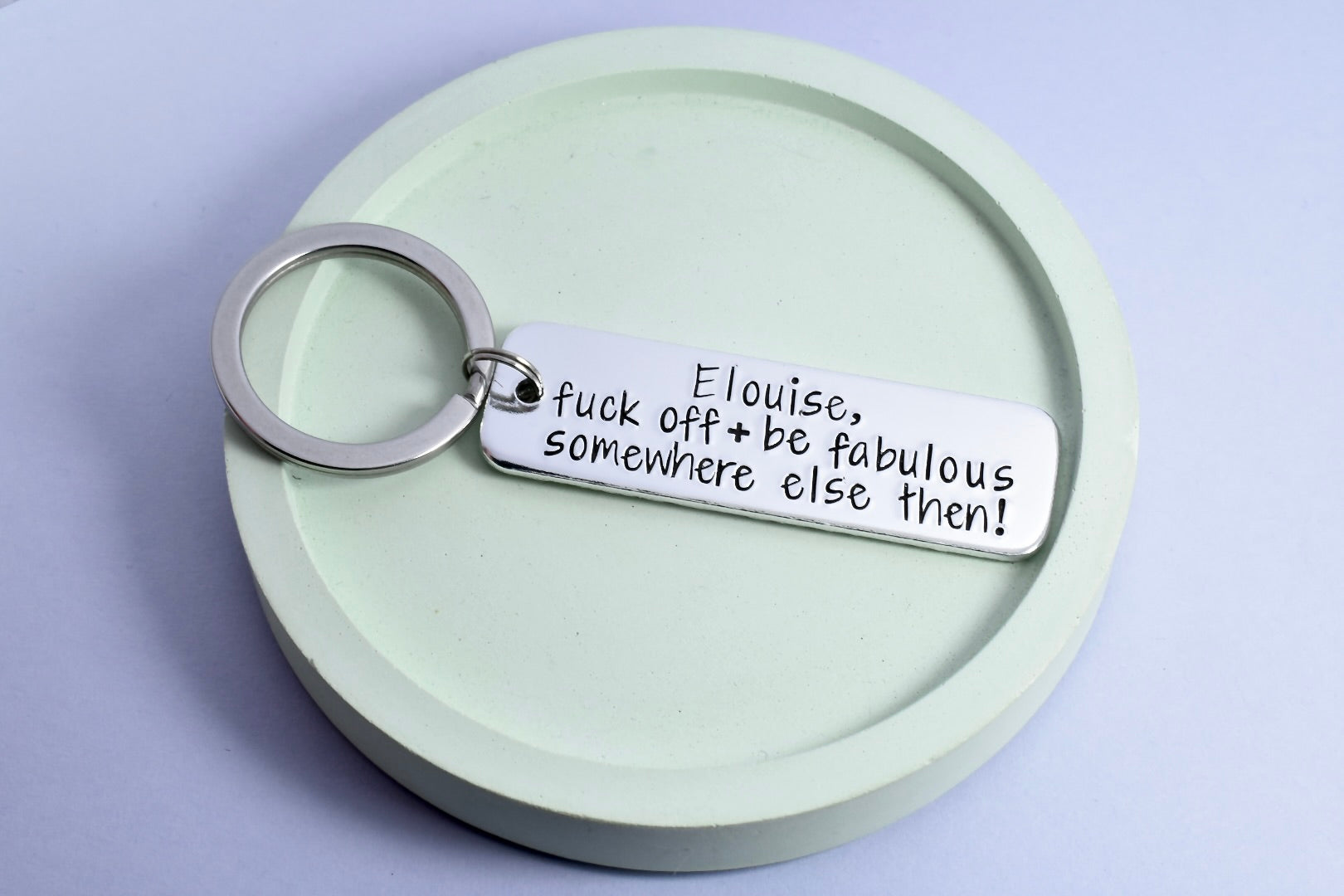 Personalised, aluminium rectangle keyring for someone leaving you. Text says "fuck off and be fabulous somewhere else then!"
