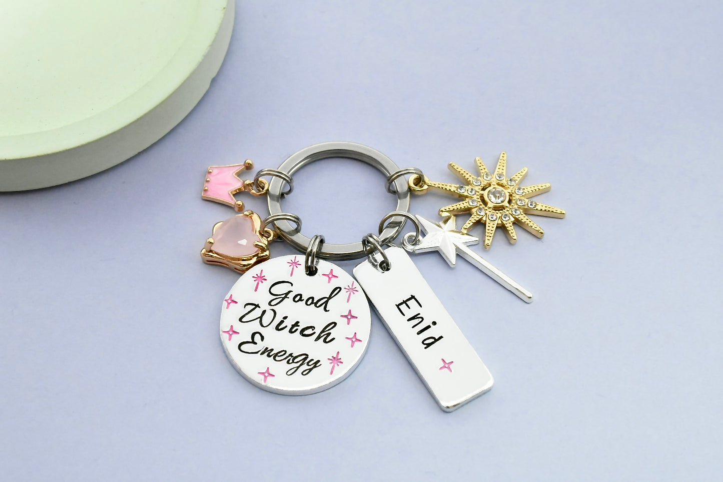 Keychain with 'Good Witch Energy' tag and various charms on a light gray background