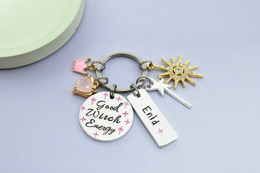 Keychain with 'Good Witch Energy' tag and various charms on a light gray background