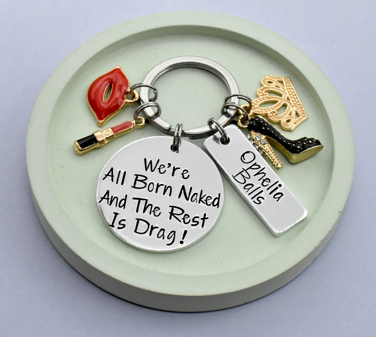 GLAM KEYRING WITH THE PHRASE " WE'RE ALL BORN NAKED AND THE REST IS DRAG" ON IT WITH GLAM CHARMS