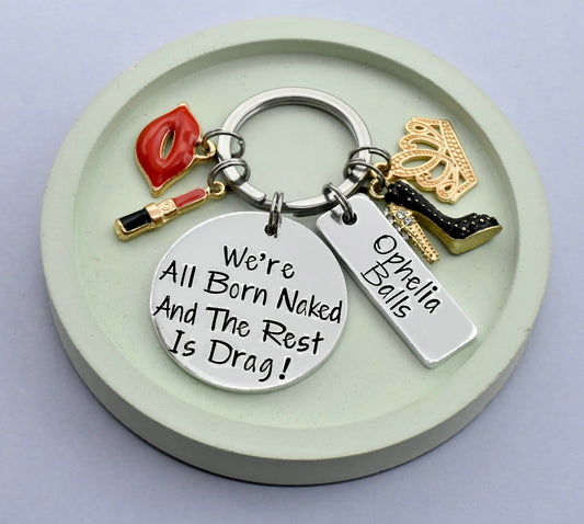 GLAM KEYRING WITH THE PHRASE " WE'RE ALL BORN NAKED AND THE REST IS DRAG" ON IT WITH GLAM CHARMS