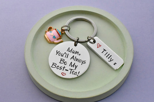 Keychain with personalized tag and tea cup charm on a green plate