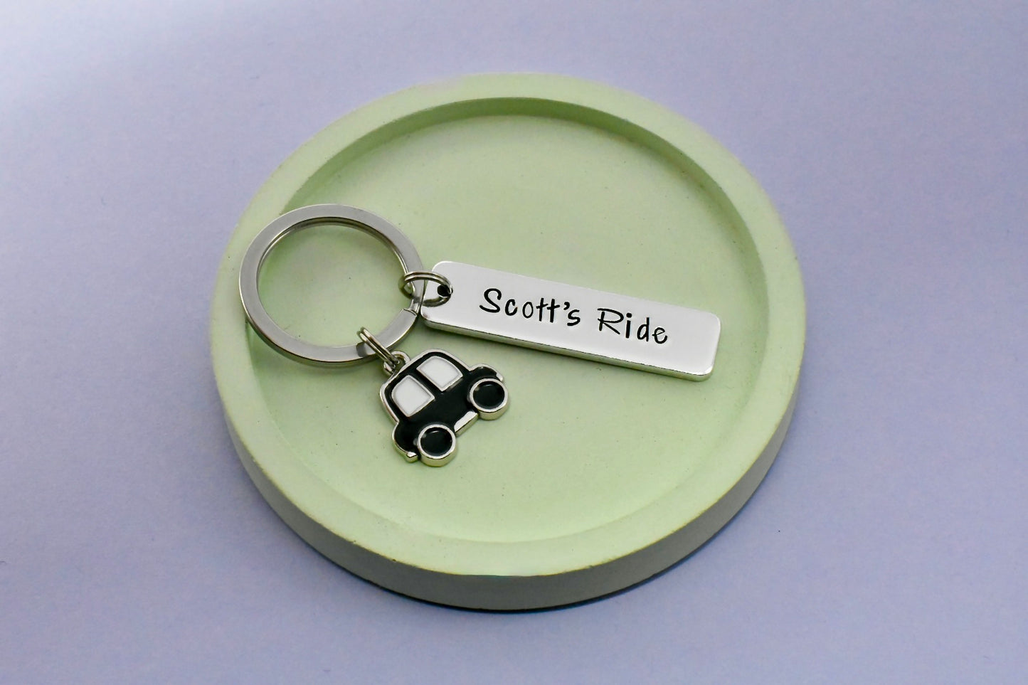 Keychain with 'Scott's Ride' tag and car charm on a green round base