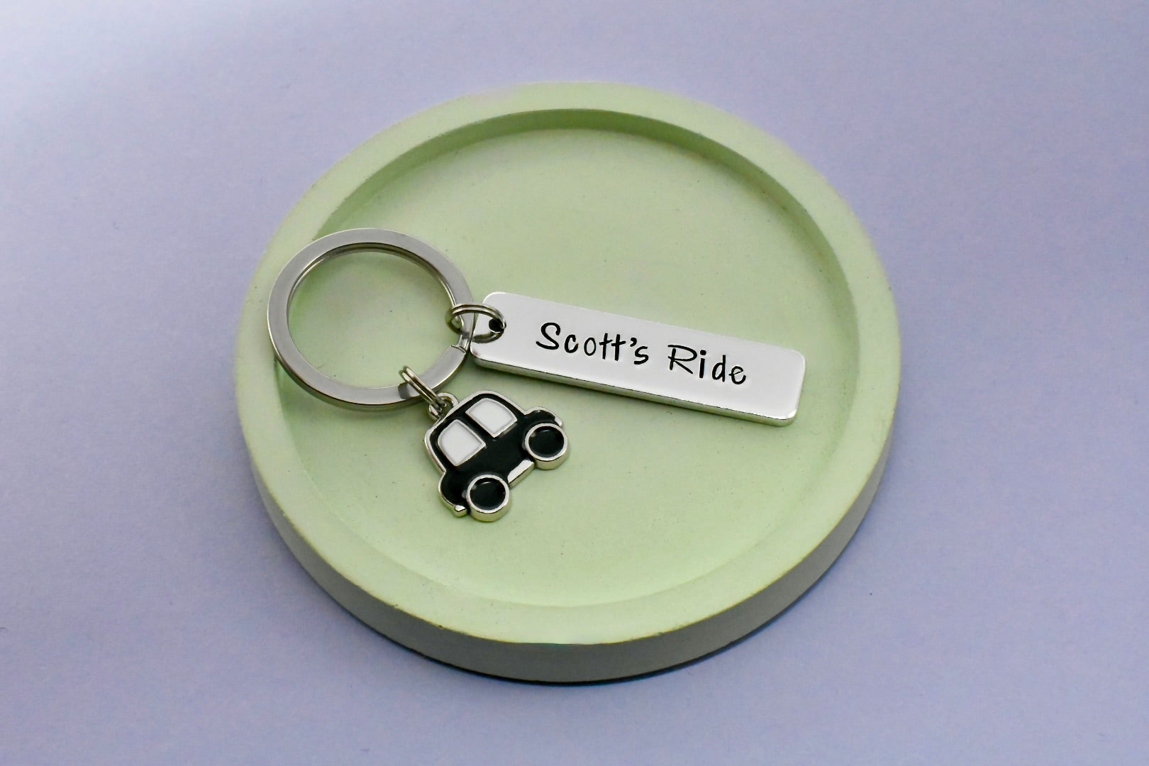 Keychain with 'Scott's Ride' tag and car charm on a green round base
