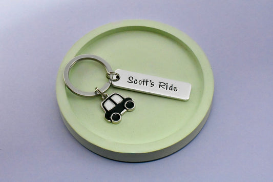 Keychain with 'Scott's Ride' tag and car charm on a green round base
