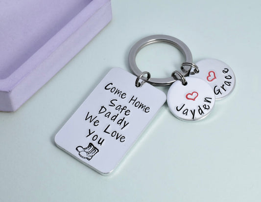 A personalised aluminium keyring with rectangular and small disc charms. The rectangular charm has the text 'Come Home Safe Daddy We Love You' and a heart symbol. Discs are personalised with children's names and red heart design