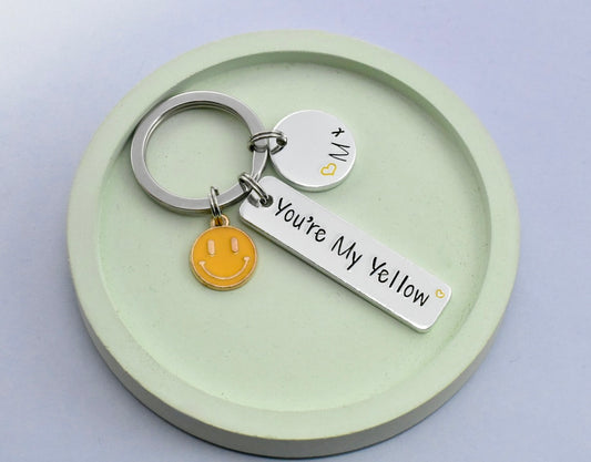 Keychain with 'You're My Yellow' tag and smiley face charm on a green dish