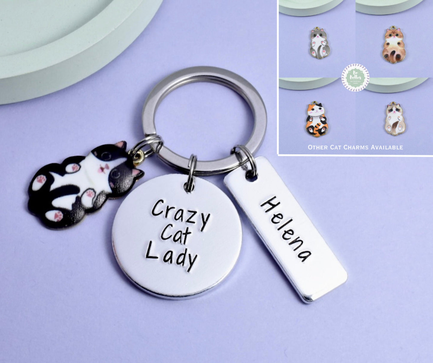 A personalised keyring with an aluminium disc stamped with 'Crazy Cat Lady' and a small cat charm, alongside other cat-shaped charms.
