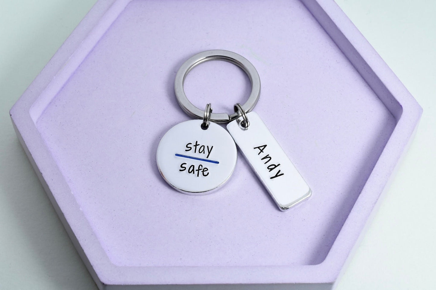 A personalised keyring with a 'STAY SAFE' message, police thin blue line design, and rectangle is stmaped with officers name or number