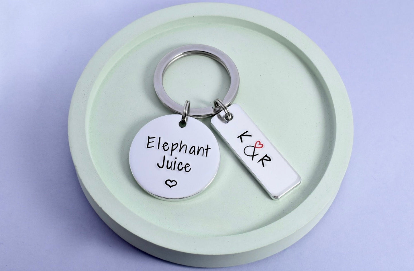 A keyring with two aluminium tags, one stamped with 'Elephant Juice' and the other personalised with initials,