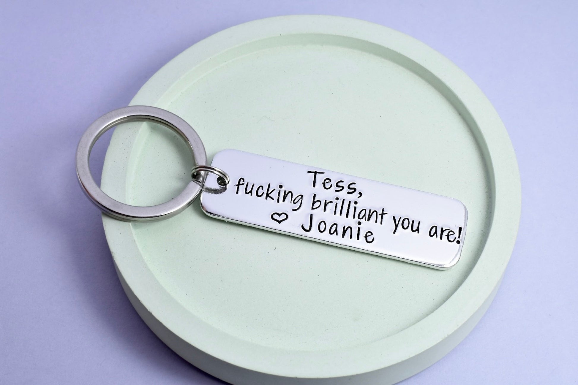 A personalised keyring with the inscription 'FUCKING BRILLIANT YOU ARE!' stamped 